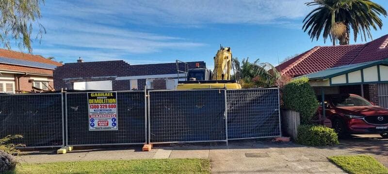 Gabrael fencing enclosing a residential work site with an excavator visible behind